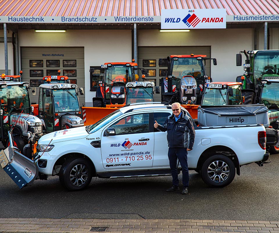 Mitarbeiter bei AGS Wild & Panda vor dem Fuhrpark